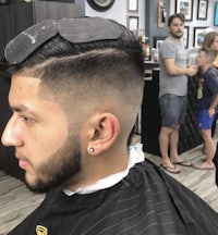 a man is getting his hair cut in a barber shop